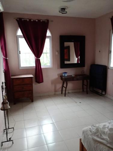 a bedroom with a bed and a mirror and a table at En planta alta a pie de avenida in Cozumel