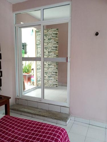 a bedroom with a window and a red bed at En planta alta a pie de avenida in Cozumel