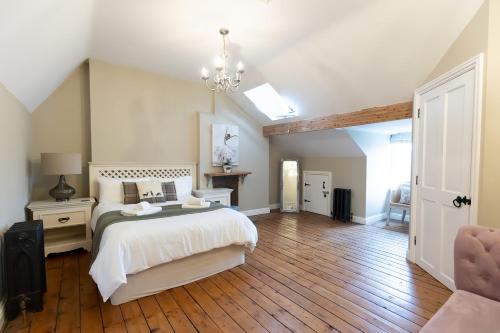 a bedroom with a large white bed and wooden floors at HIGH SAINT COTTAGE - Stunning 3 Bed Accommodation located in Ripon, North Yorkshire in Ripon