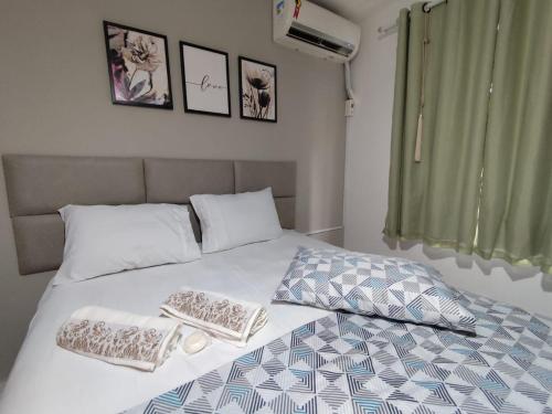 un lit avec deux oreillers dessus dans l'établissement Ap em Balneário Camboriú, à Balneário Camboriú