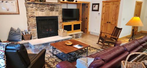 a living room with a couch and a fireplace at Sundance Spacious Vaulted Ceiling cabin, Hot tub, huge lawn in Sundance
