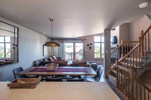 un soggiorno con un tavolo e un divano di Clairiere 404 - Spectacular Mont-Tremblant Chalet a Mont-Tremblant
