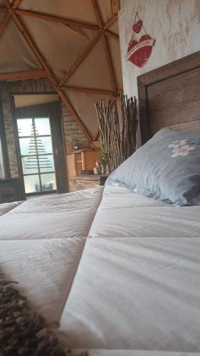a large white bed in a room with a window at Domobosque in Ancud