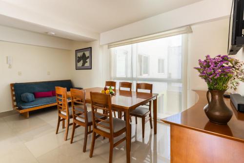 a dining room with a table and chairs and a couch at C101 - 2BR - 2BTh in Mexico City