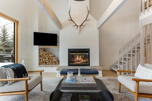 a living room with a fireplace and a tv at Novelle Chalet - Renovated, Chic Contemporary Home on Gore Creek with Hot Tub in Vail