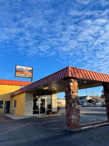 a gas station with a building with a red roof at High Desert Inn in Prineville