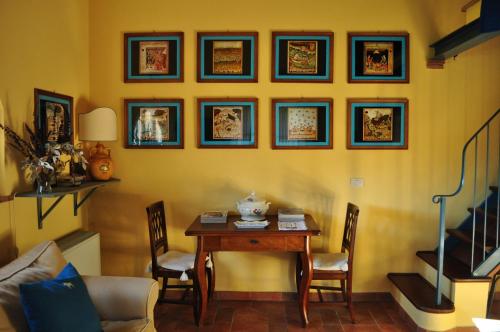 a dining room with a table with chairs and pictures on the wall at Podere L'Olmaia in Marsiliana