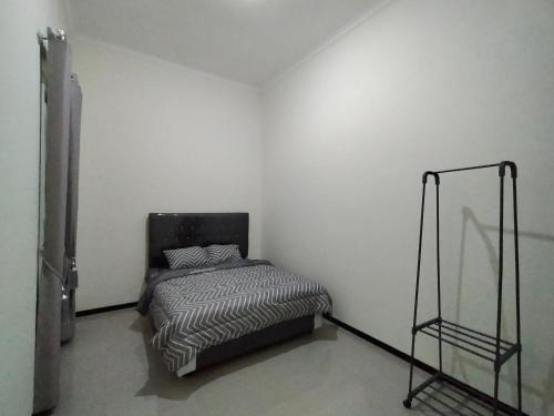 BAROKAH Cordoba Homestay 1 Rumah dgn 3 Kamar في Tlekung: غرفة نوم بسرير في جدار أبيض