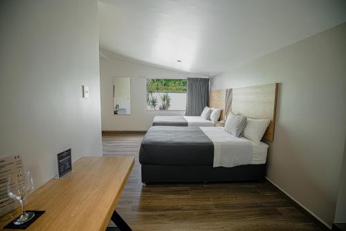 a bedroom with two beds and a table and a window at Hotel Garcia Peral in Huajuapan de León