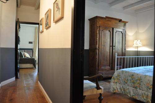 a bedroom with a bed and a wooden cabinet at Podere L'Olmaia in Marsiliana