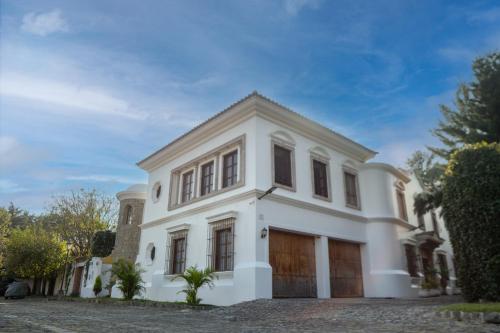 a white house with a garage at Indian Palace Hotel Boutique Spa & Restaurante in Antigua Guatemala