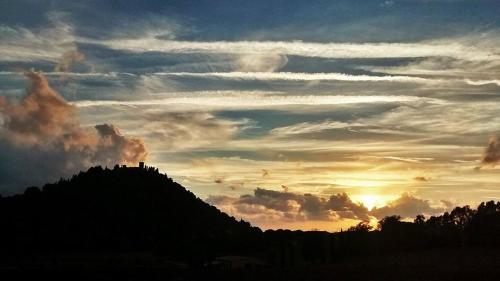 a silhouette of a mountain with a sunset in the background at Podere L'Olmaia in Marsiliana