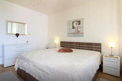 a white bedroom with a large bed and a window at Apartment Ultra Split in Split