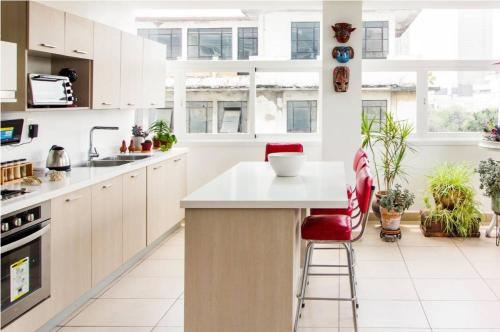 a kitchen with white cabinets and red bar stools at J607 - 2BDR - 1BTh in Mexico City