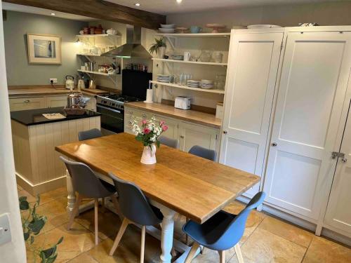 eine Küche mit einem Holztisch und Stühlen in der Unterkunft Cottage c1790, Superb central Witney, free parking in Witney