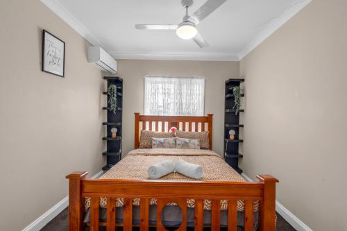 ein Schlafzimmer mit einem Holzbett mit zwei Kissen in der Unterkunft Quaint 2 bedroom fully furnished Cottage in Warwick