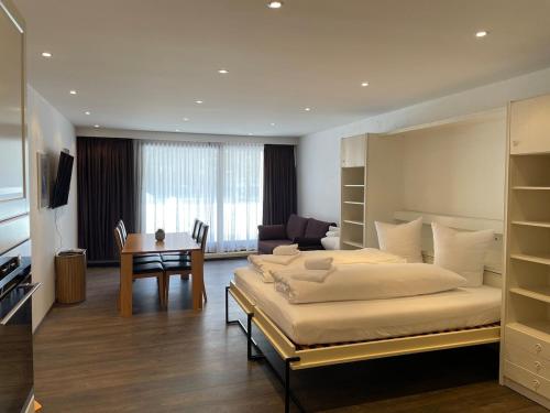 a large bedroom with a large bed and a desk at Apartment with Pool, Sauna & Gym in Laax