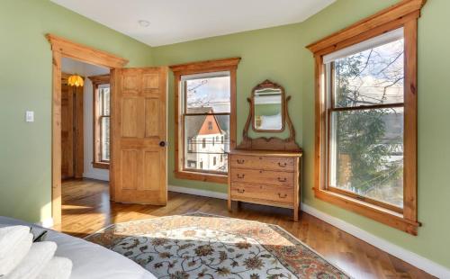 a bedroom with a mirror and a dresser and windows at Victorian Lake Oasis Hot Tub Private Lakefront in Lake Huntington