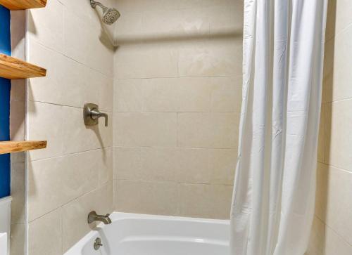 a bathroom with a shower with a white shower curtain at Victorian Lake Oasis Hot Tub Private Lakefront in Lake Huntington
