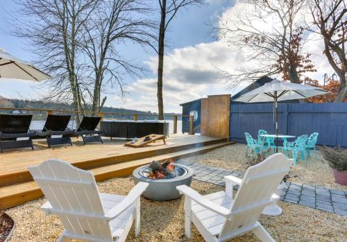 a backyard with two chairs and a fire pit at Victorian Lake Oasis Hot Tub Private Lakefront in Lake Huntington