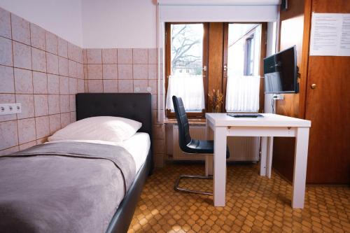 ein Schlafzimmer mit einem Bett und einem Schreibtisch mit einem Computer in der Unterkunft Einfache Unterkunft in Michelstadt
