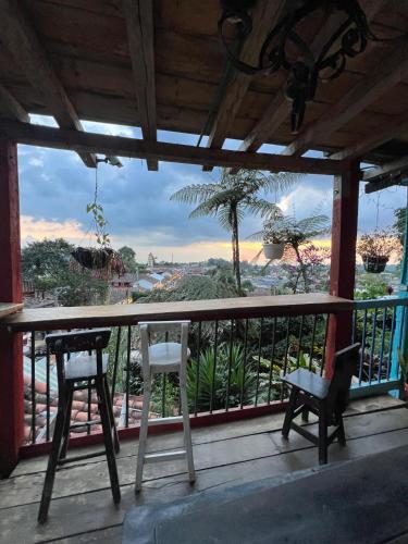 a balcony with two chairs and a view of the ocean at Atardecer De Salento in Salento
