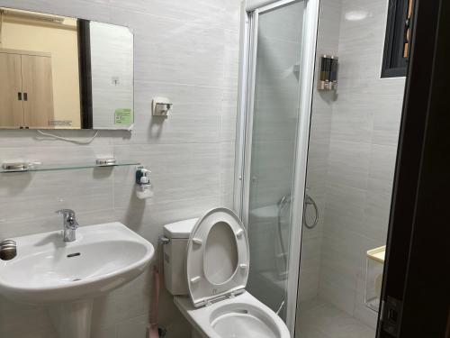 a bathroom with a sink and a toilet and a shower at Daisy's Hsiang Hola in Chiayi City