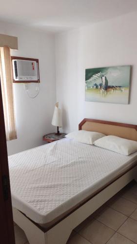 a bedroom with a bed with a white bedspread at Encanto da Lagoa in Iguaba Grande