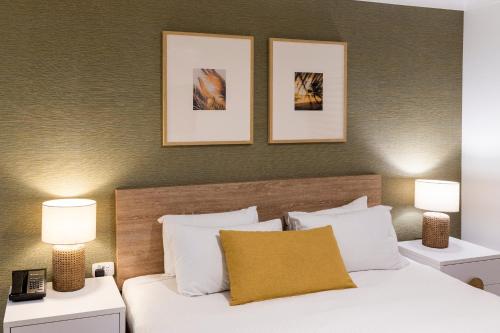 a bedroom with a white bed with two lamps at Turtle Beach Resort - Accor Vacation Club Apartments in Gold Coast