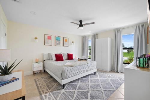 a bedroom with a bed with red pillows at Chic 4BR Home Hot Tub Game Room in Port Saint Lucie