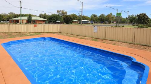 a large blue swimming pool with a fence at RAMS Motel in Coonamble