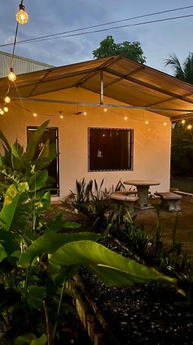 a house with a picnic table in front of it at Corcovado House With AC in Puerto Jiménez