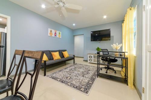 a living room with a couch and a table at The Black Pineapple - Mercys Place in Saint Johnʼs