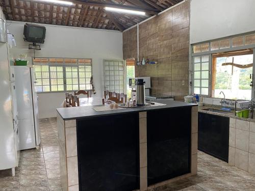 a large kitchen with a large island in the middle at Pouso Panorama - Serra da Canastra in São João Batista do Glória