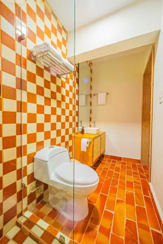 a bathroom with a toilet and a glass shower at Casona Quetzal in Guadalajara