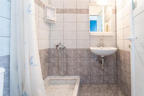 un baño con lavabo y ducha en Liberis studios, en Razáta