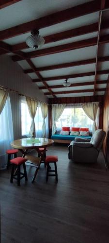 a living room with a table and a couch at Hostal Maravillas del Sur in Villarrica