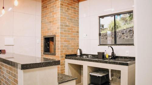a bathroom with a sink and a window at Tiny House - Centro Concórdia in Concordia