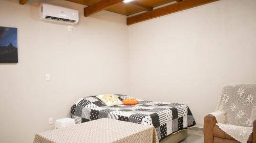 a living room with a bed and a chair at Tiny House - Centro Concórdia in Concordia
