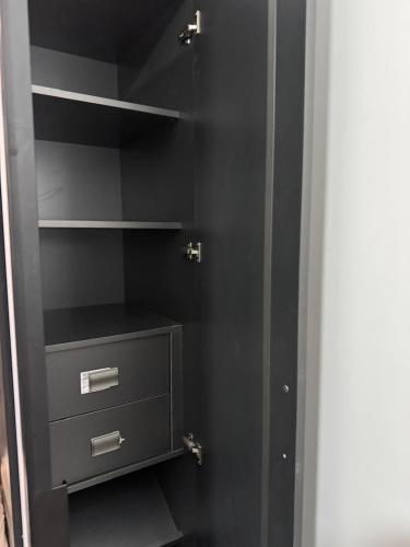 a black closet with two drawers and a shelf at Tranquility Love Bay in Richmond