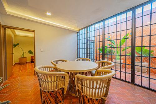 a table and chairs in a room with a window at Casona Quetzal in Guadalajara