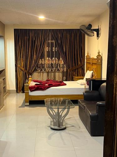a bedroom with a bed and a couch in a room at Rysons Continental Hotel in Rawalpindi