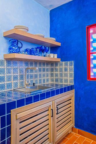 a blue kitchen with a sink and a blue wall at Casona Quetzal in Guadalajara