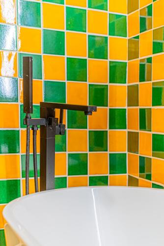 a toilet in a bathroom with colorful tiles on the wall at Casona Quetzal in Guadalajara