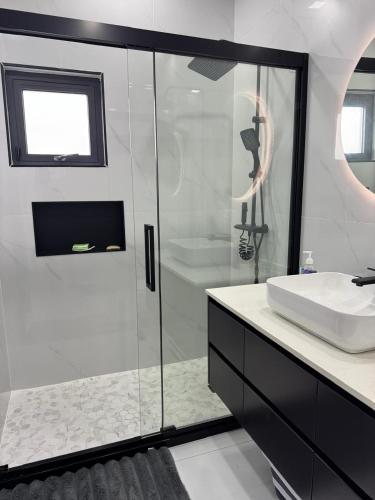 a bathroom with a glass shower and a sink at Tranquility Love Bay in Richmond