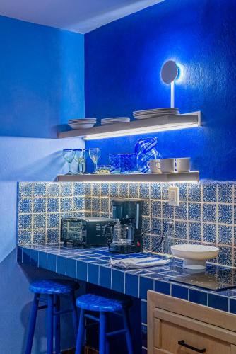 a blue kitchen with a counter with two blue stools at Casona Quetzal in Guadalajara