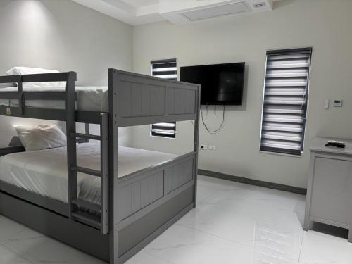 a bedroom with two bunk beds and a flat screen tv at Tranquility Love Bay in Richmond
