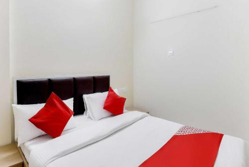 a bedroom with a bed with red and white pillows at Hotel O Zion Inn in Vapi