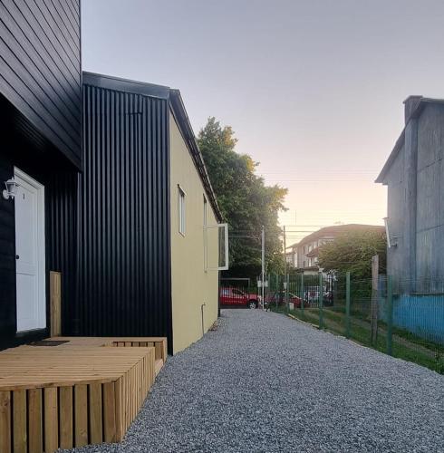 a building with a gravel sidewalk next to a building at cabaña centrica con vista al rio in Valdivia