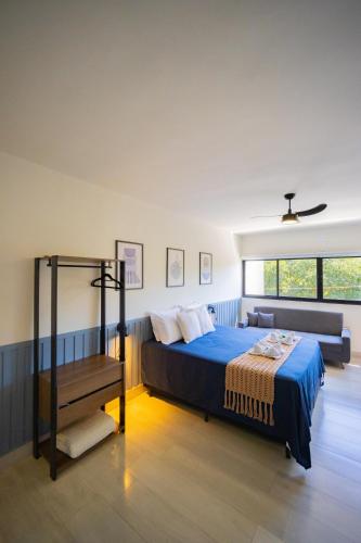 a bedroom with a bed and a couch at Mont Sunset Loft l Exclusividade & Conforto in Águas de Lindoia